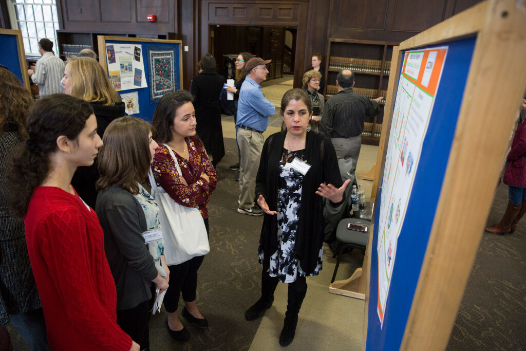 A faculty member presents research to graduate students.